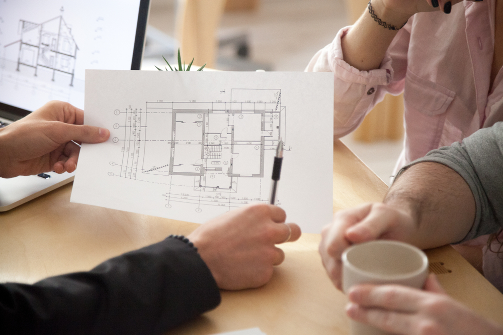 Architect,or,interior,designer,showing,new,apartment,plan,to,couple